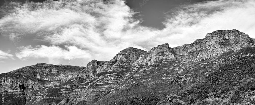 Black and white landscape of mountains on a cloudy sky background with copy space. Nature view of po