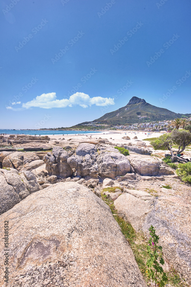 炎热的夏天，山附近海滩上的大石头，背景是蓝天。风景