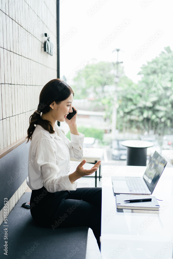 亚洲女性在办公室里用笔记本电脑工作。商业金融概念。