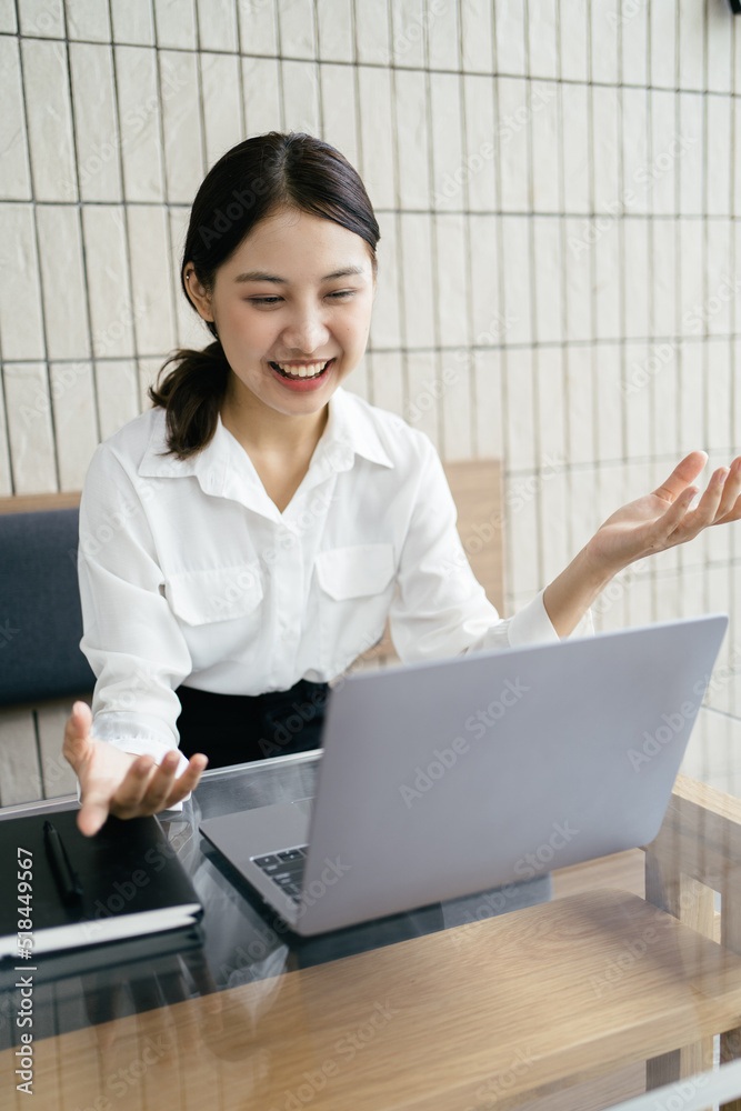 漂亮的亚洲女人在客厅里用笔记本电脑。