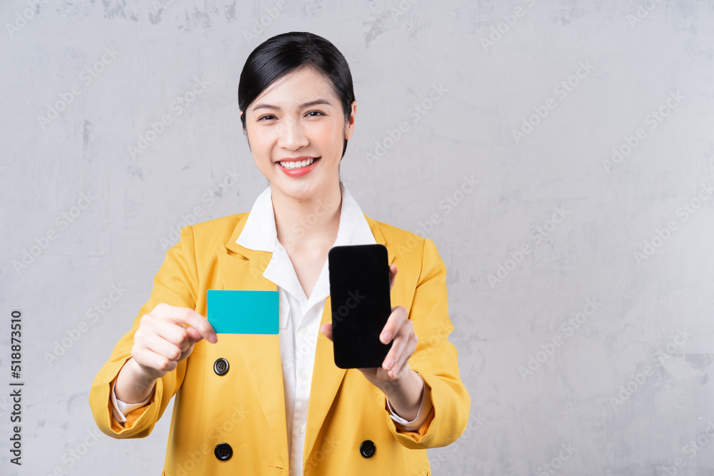 Image of young Asian woman holding bank card