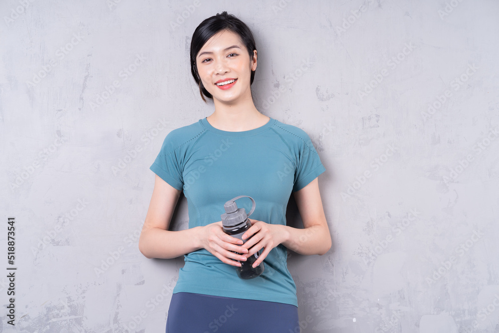 Photo of young Asian woman holding water bottle