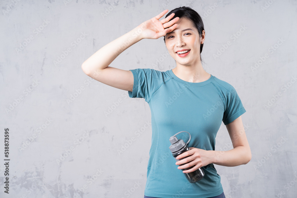 Photo of young Asian woman holding water bottle