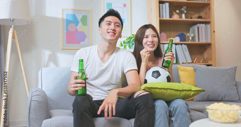 asian couple watching soccer game