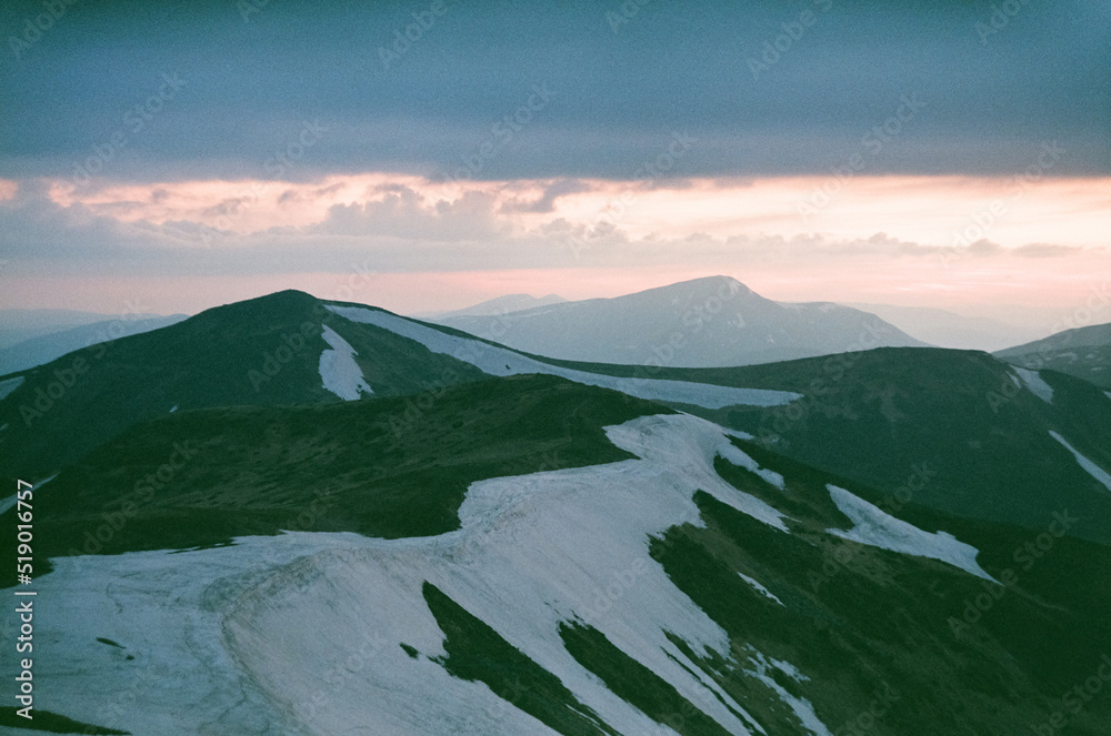 日落时的雪山景观。戏剧性的春天场景。用谷物扫描真实的电影。陆地