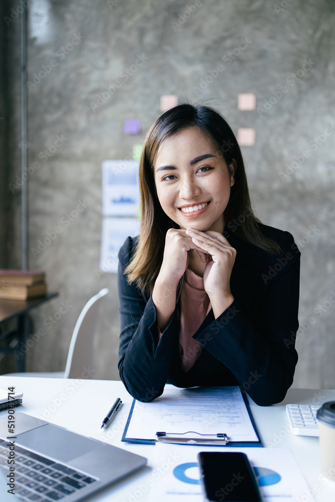 亚洲女性在办公室里用笔记本电脑工作。商业金融概念。