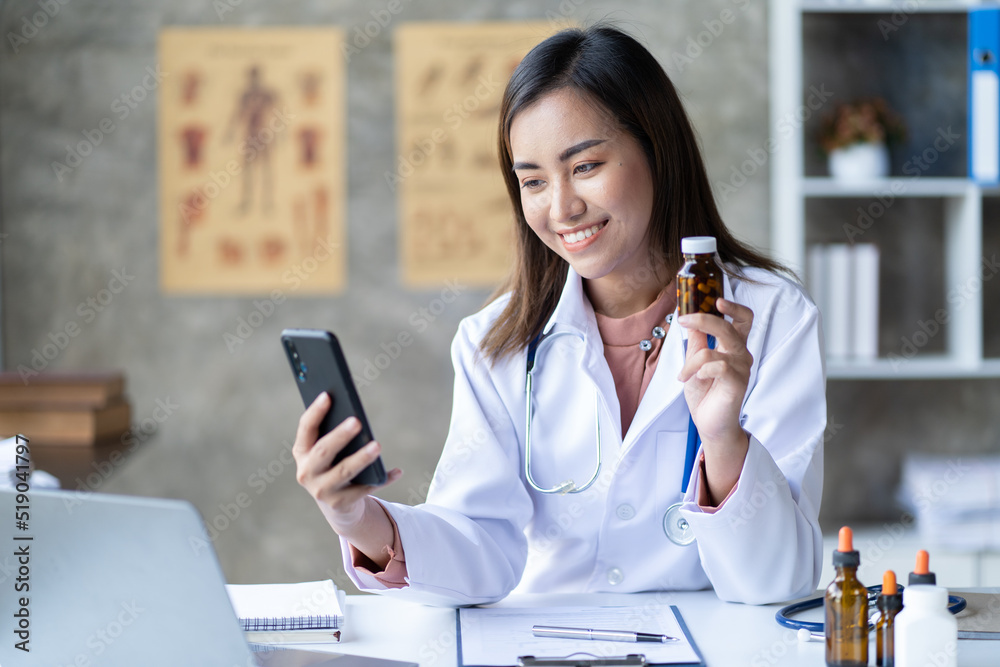 Asian female doctor using laptop computer online video call remote talking to patient.