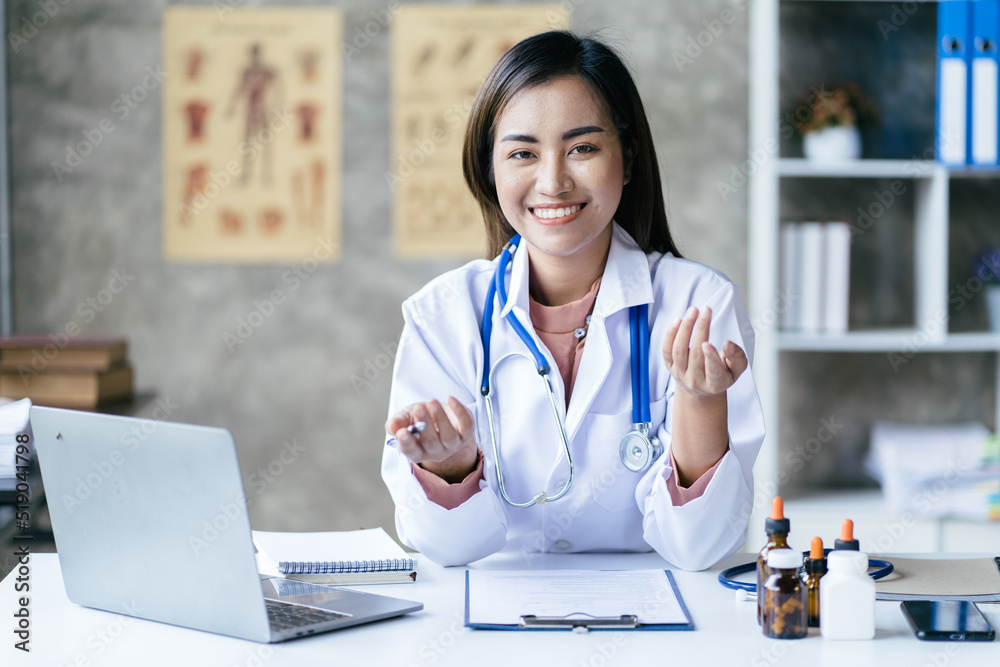 Asian female doctor using laptop computer online video call remote talking to patient.