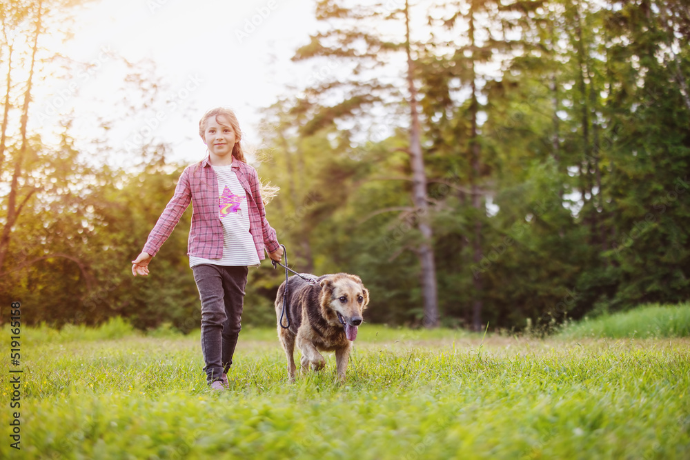 Child walking with a dog in nature