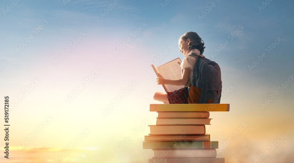 child on the tower of books