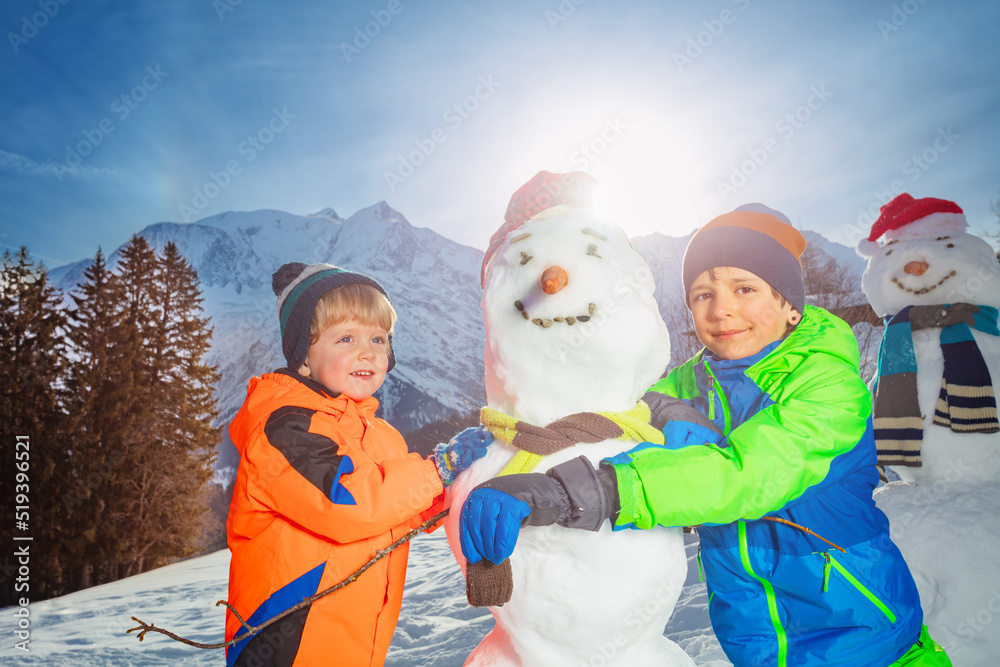 孩子们在外面的山上堆雪人和给雪人穿衣服