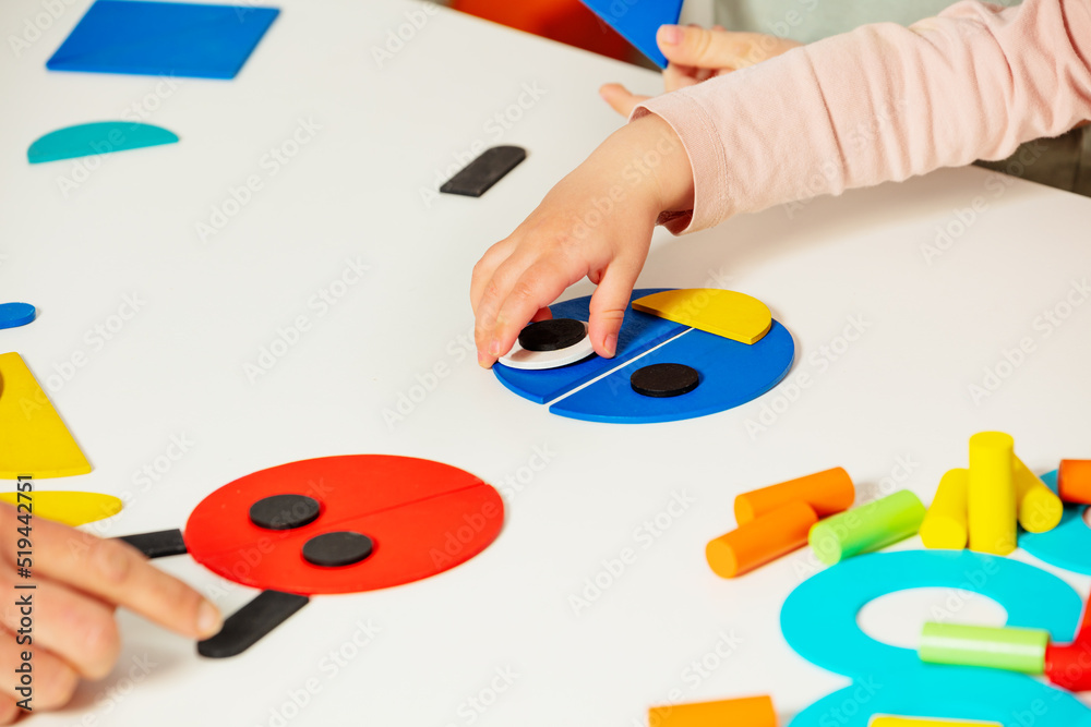 Childs hand put together shapes to create a bug