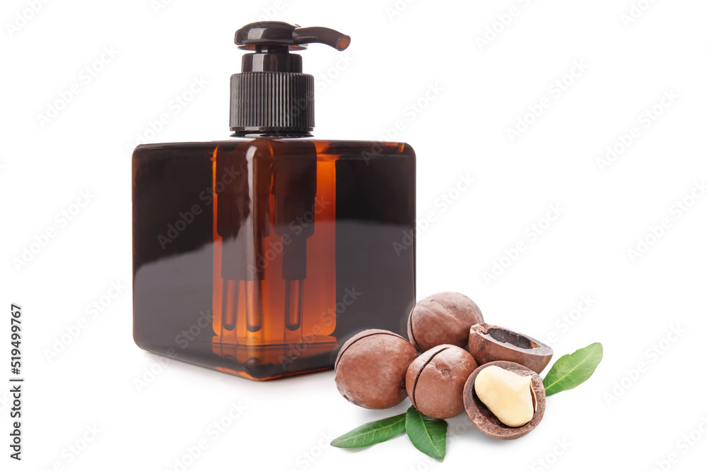 Bottle of natural cosmetics with macadamia nuts on white background