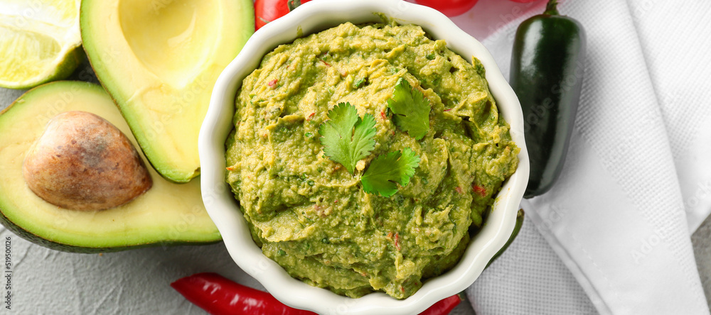 Bowl with delicious guacamole on table, top view