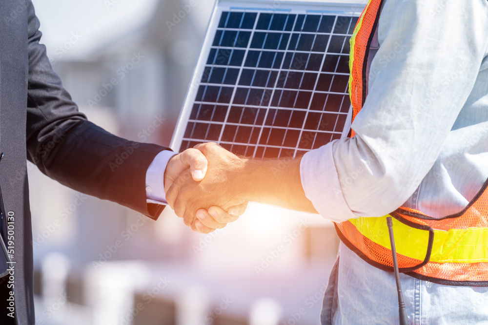 Close up businessman and engineers shaking hands after discussing install solar panels on houses und