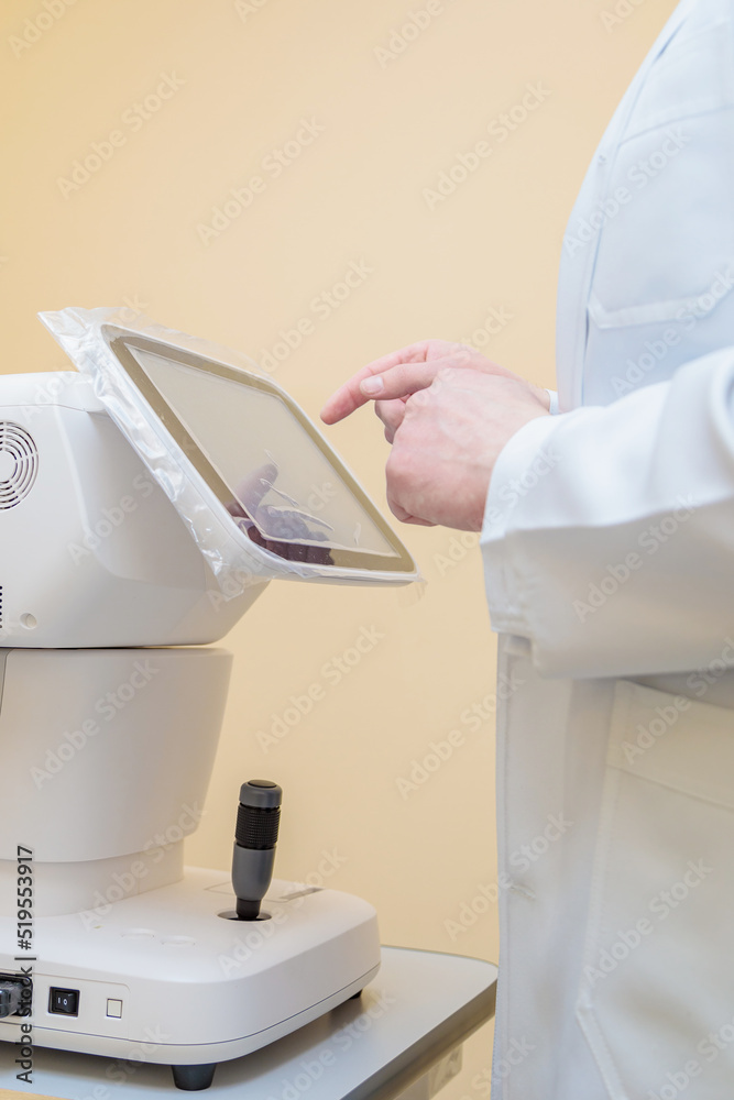 A male ophthalmologist checks a patients vision with modern equipment