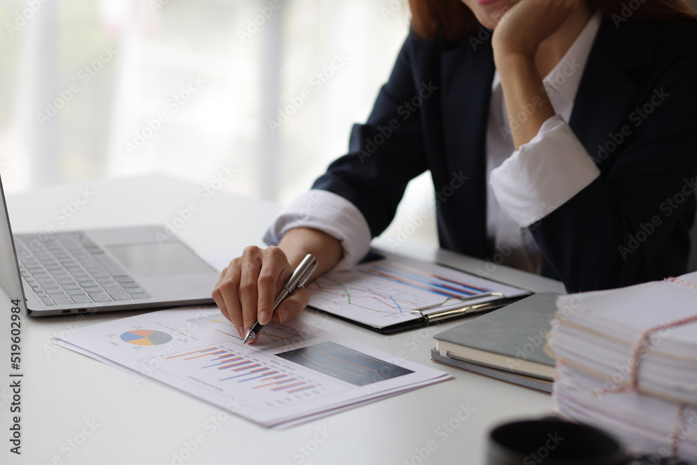 Business woman at office desk analyzing financial data and planning investment investments.