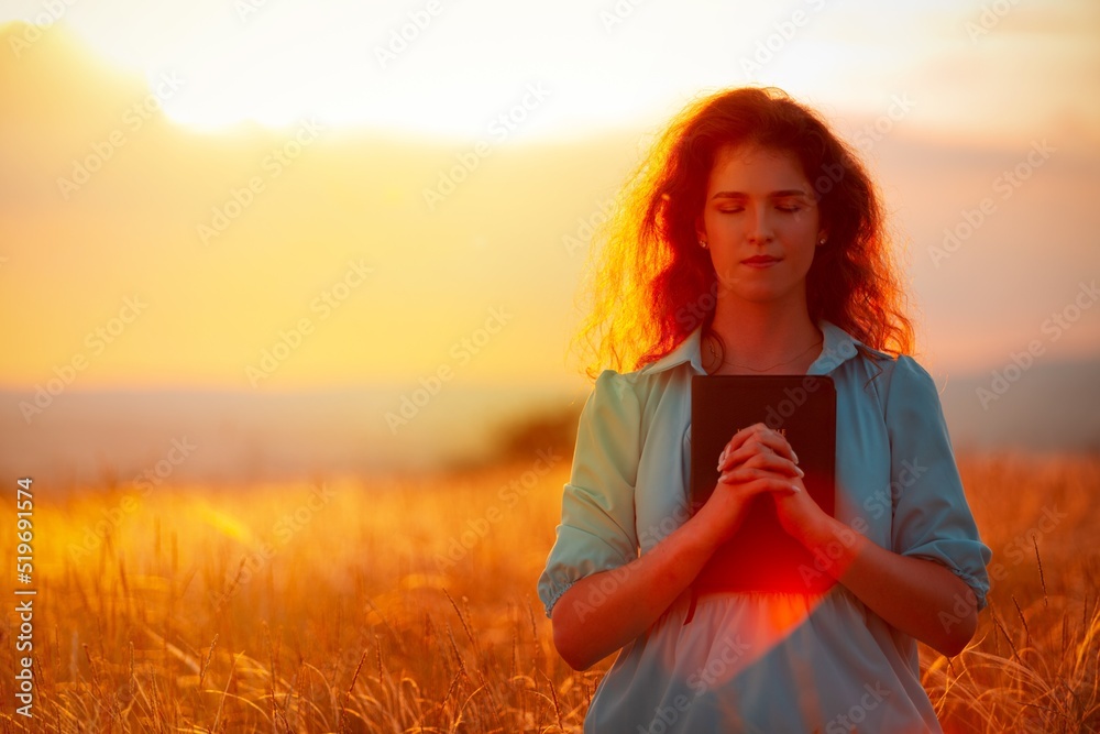 Christian woman holds bible book in her hands.