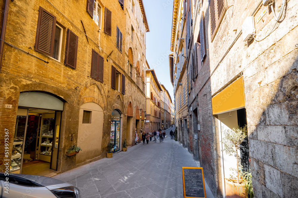 View on narrow and cozy street in the old town of Siena city in Italy. Concept of ancient architectu