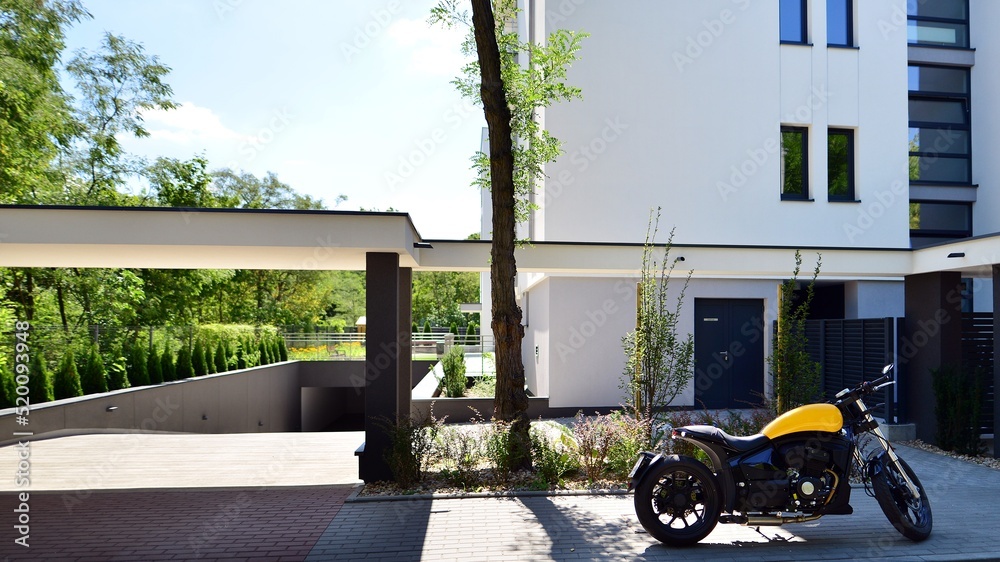 A motorcycle parked in front of apartment building.