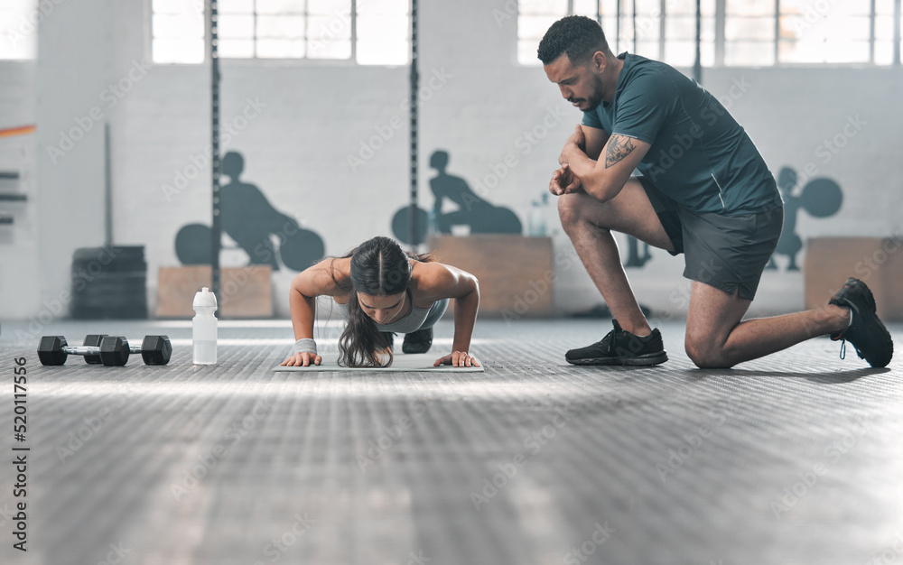 Fit and athletic woman training with her personal trainer at the gym. An active female athlete doing