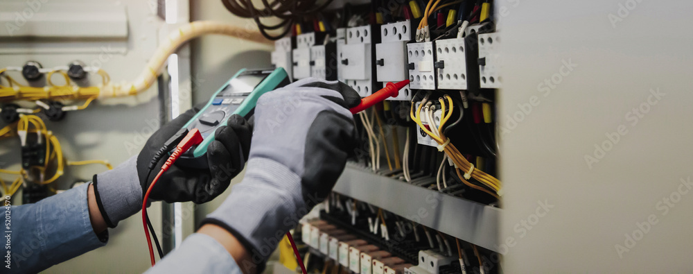 Electricity and electrical maintenance service, Engineer hand holding AC multimeter checking electri