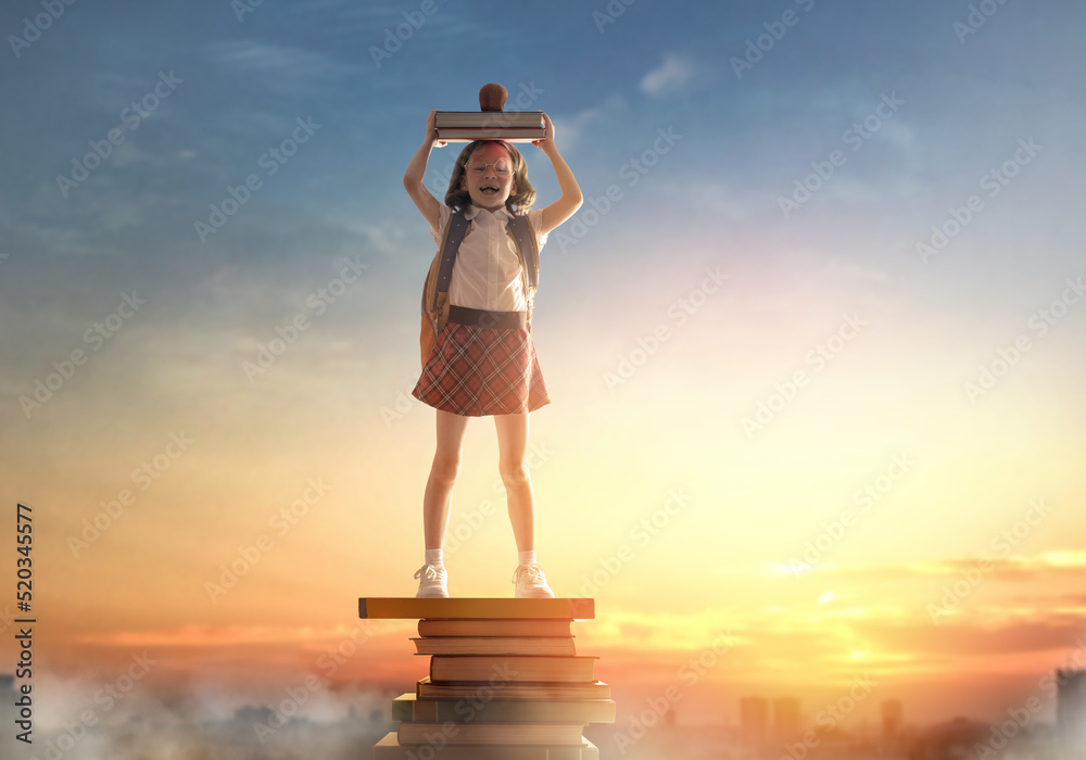 child on the tower of books