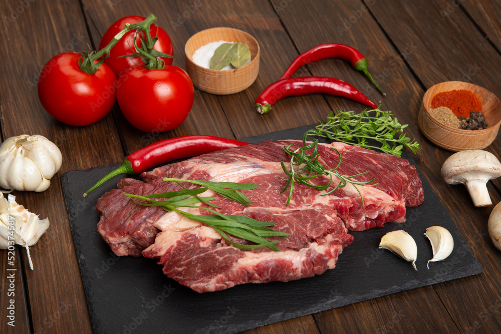 Raw beef steak on wooden table top. Healthy food concept. beef cut and spices for cooking bbq sauce