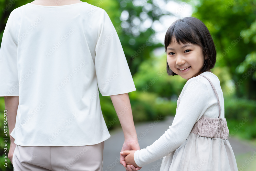 公園で手を繋ぐ女の子とお母さん