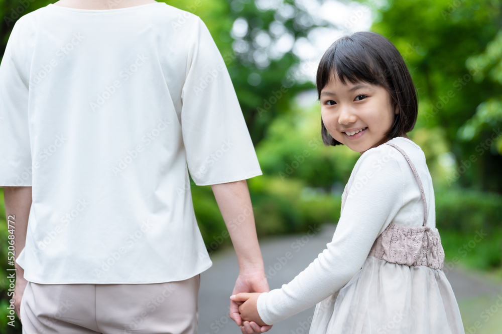 公園で手を繋ぐ女の子とお母さん