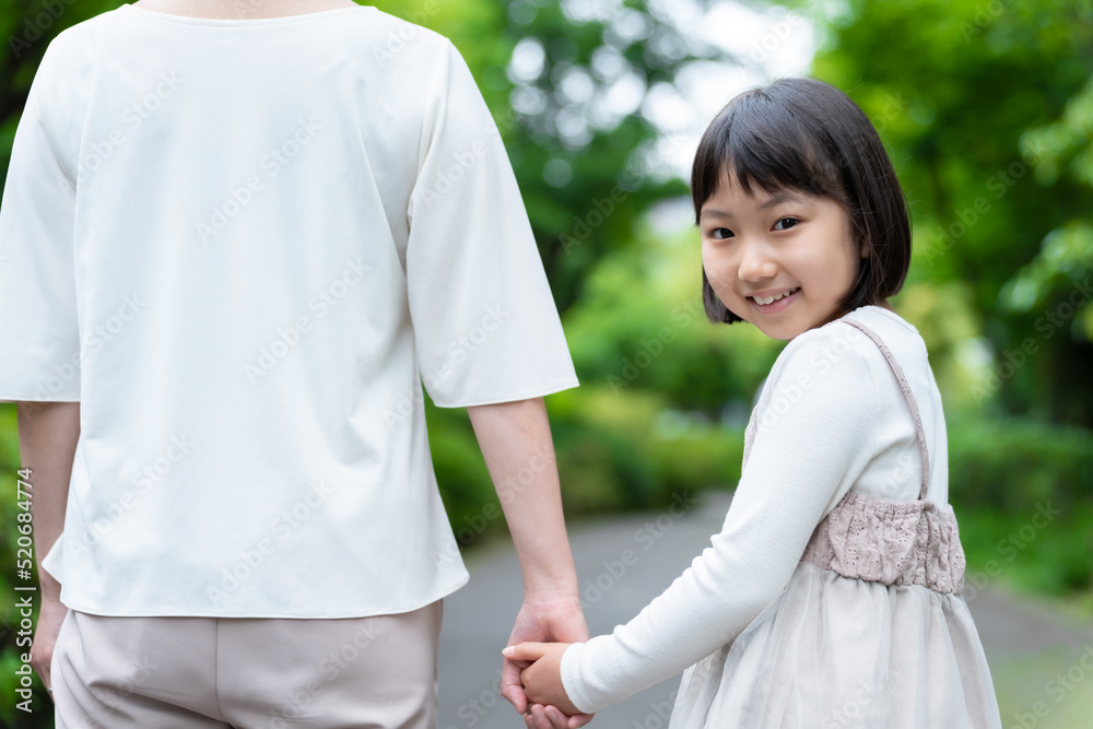 公園で手を繋ぐ女の子とお母さん