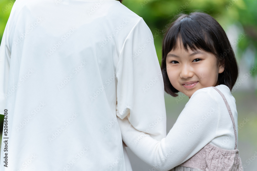 腕を組んで公園を散歩する親子