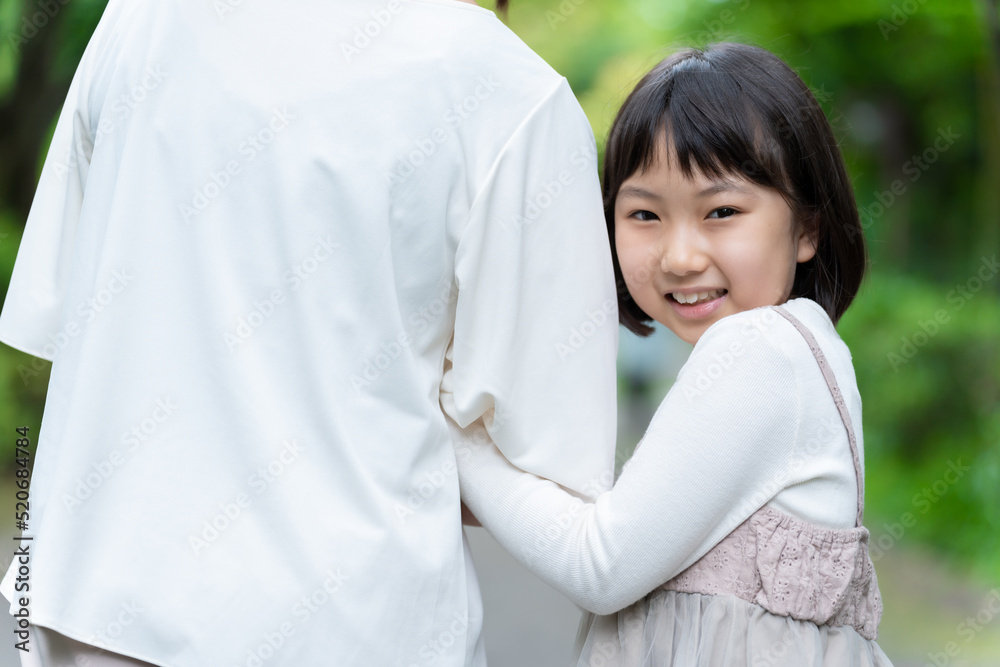 腕を組んで公園を散歩する親子