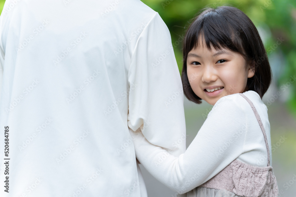 腕を組んで公園を散歩する親子