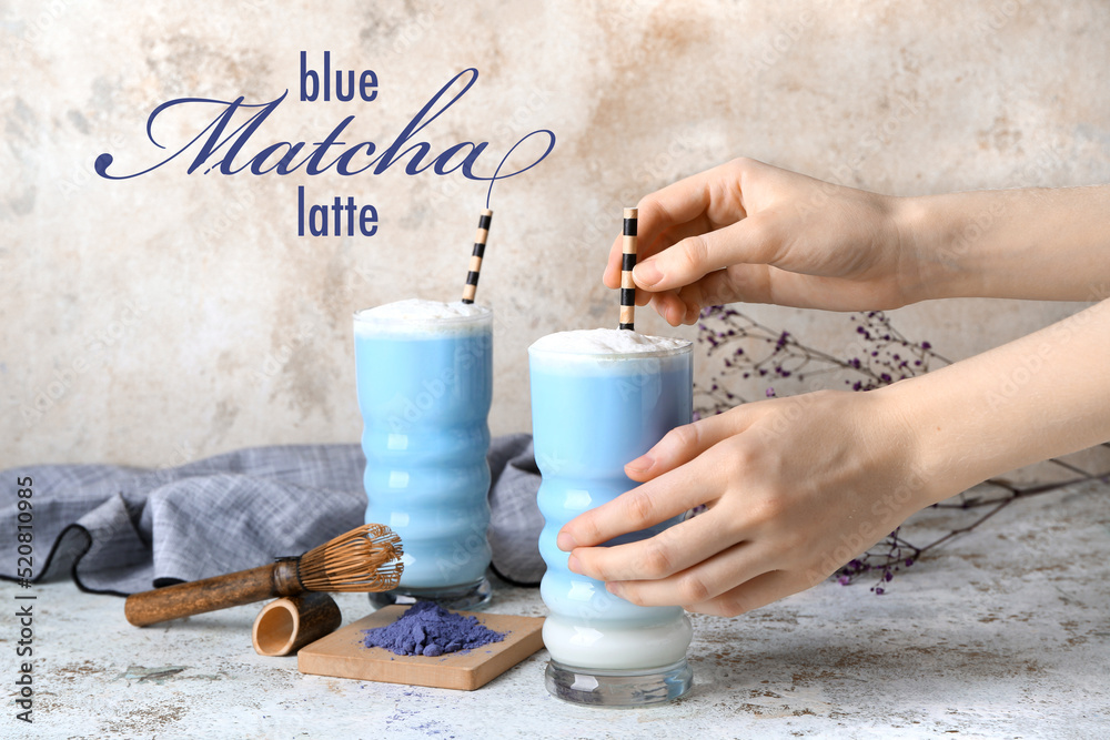 Woman making blue matcha latte on light background