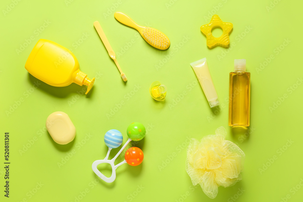 Different bath accessories for baby on green background