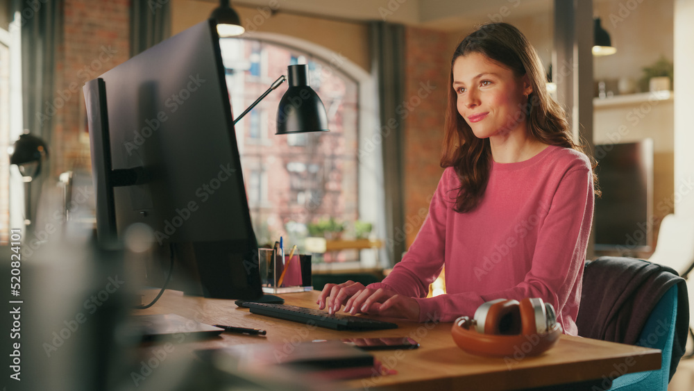 Young Beautiful Adult Woman in Pink Jumper Working from Home on Desktop Computer. Creative Female Ch