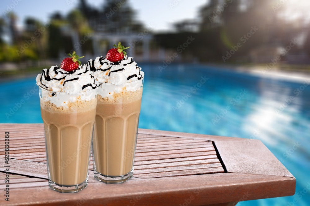 Summer holiday vacation with refreshment drink. Two ice coffee cups behind resort summer pool bar.