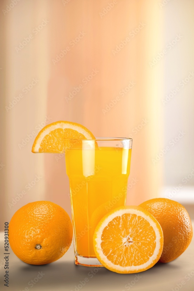 Fresh orange juice in a glass and half of orange fruit on the desk