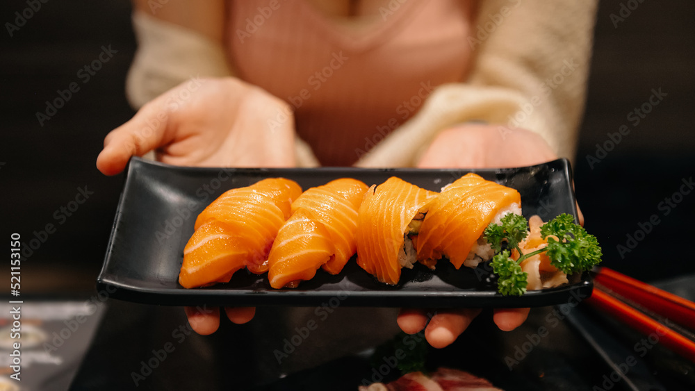 Sashimi, Salmon, Japanese food chopsticks and wasabi on the blacktable.