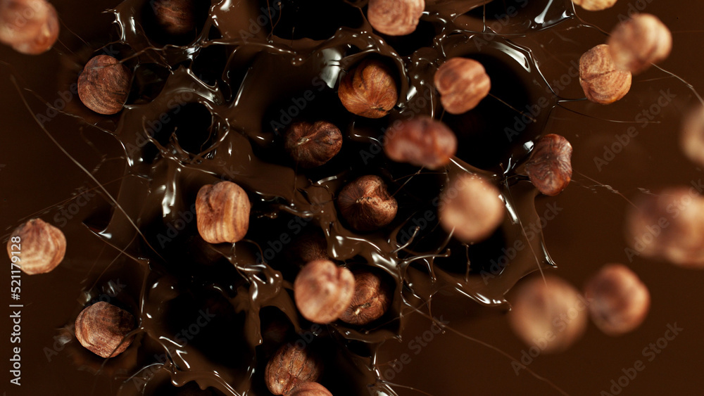 Freeze motion of falling hazelnuts into melted chocolate.