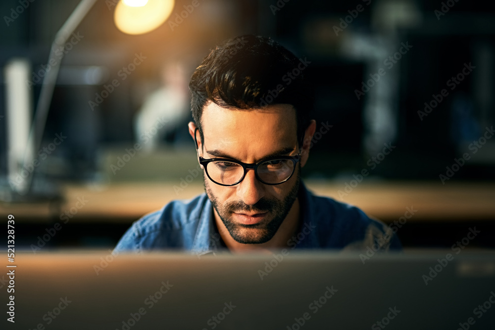 IT guy working with computer late at night, searching online while planning, thinking strategy or ty