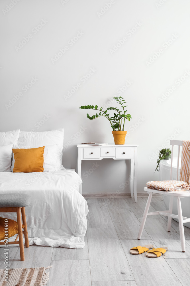 Interior of light bedroom with table and chair