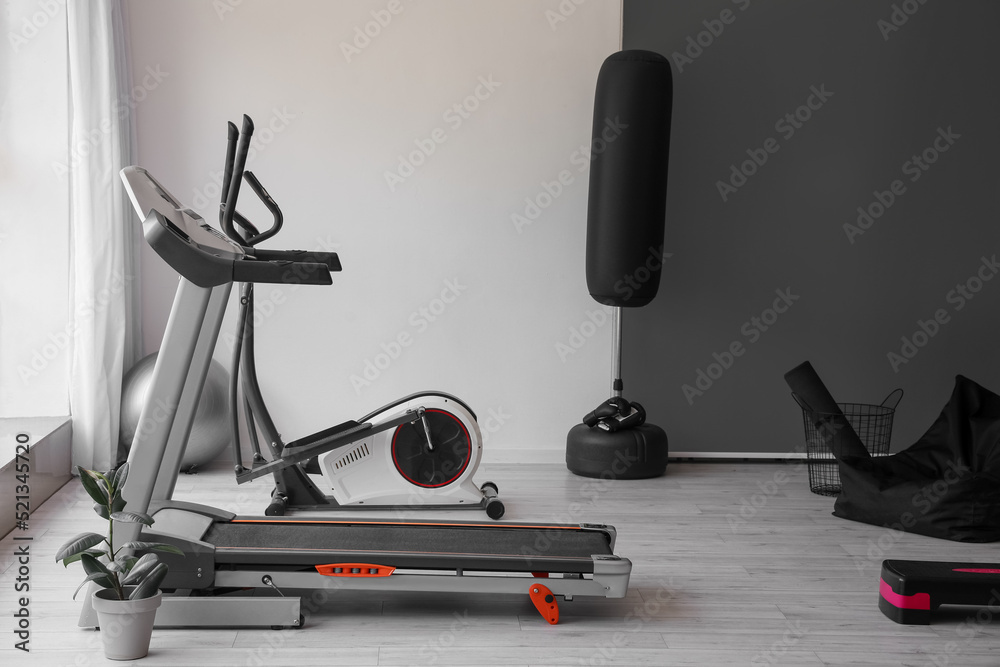 Interior of modern gym with treadmill and sport equipment