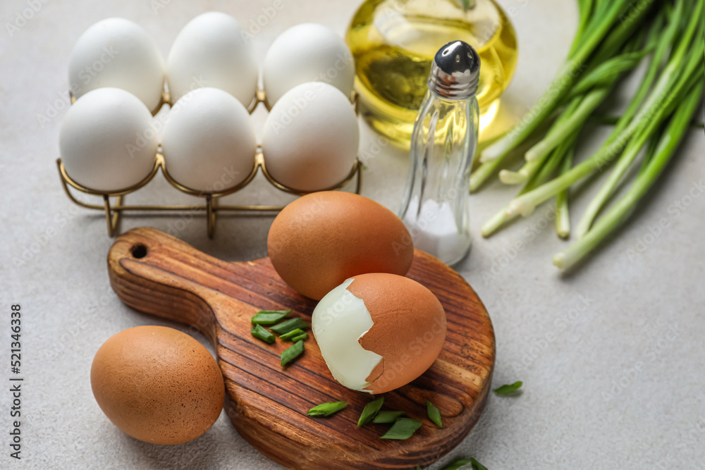 Wooden board with boiled chicken eggs on light background, closeup