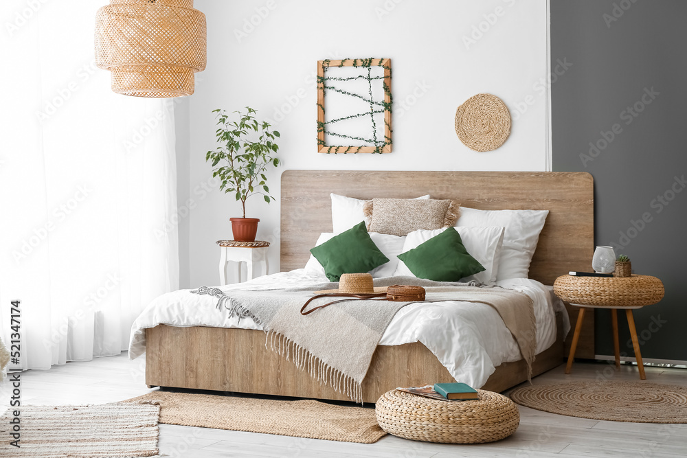 Interior of cozy bedroom with rattan poufs and accessories