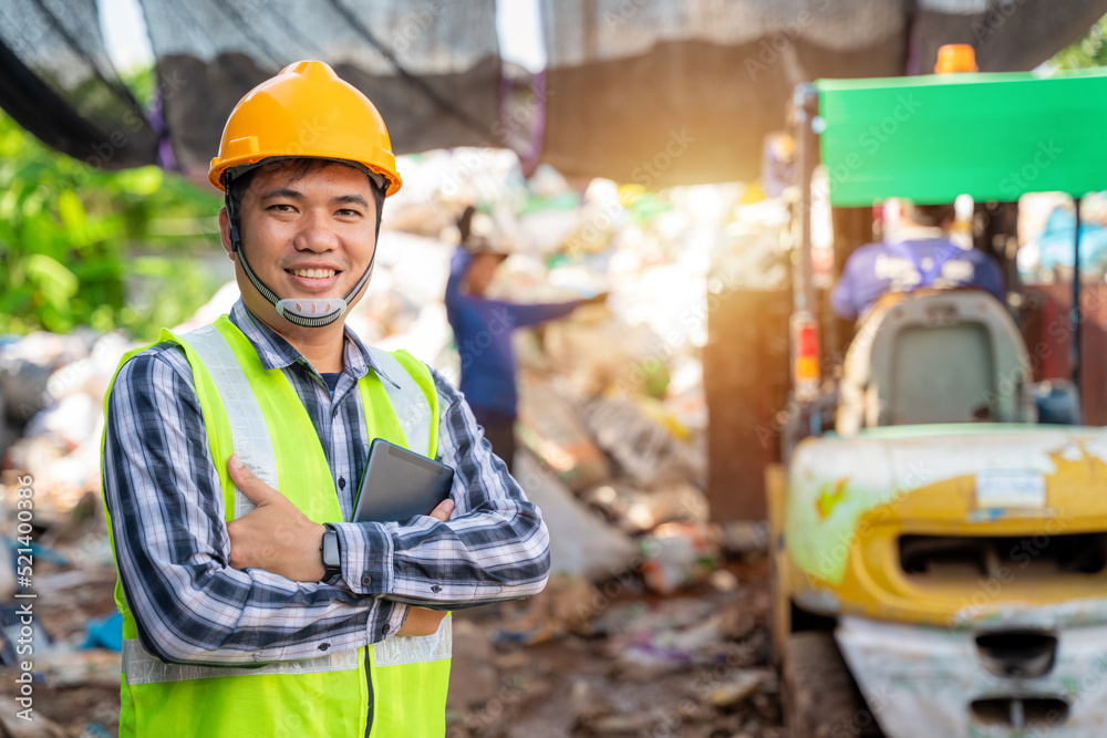 Portrait  of  Asian  workers in recycling factory with a forklift on the background, engineers stand