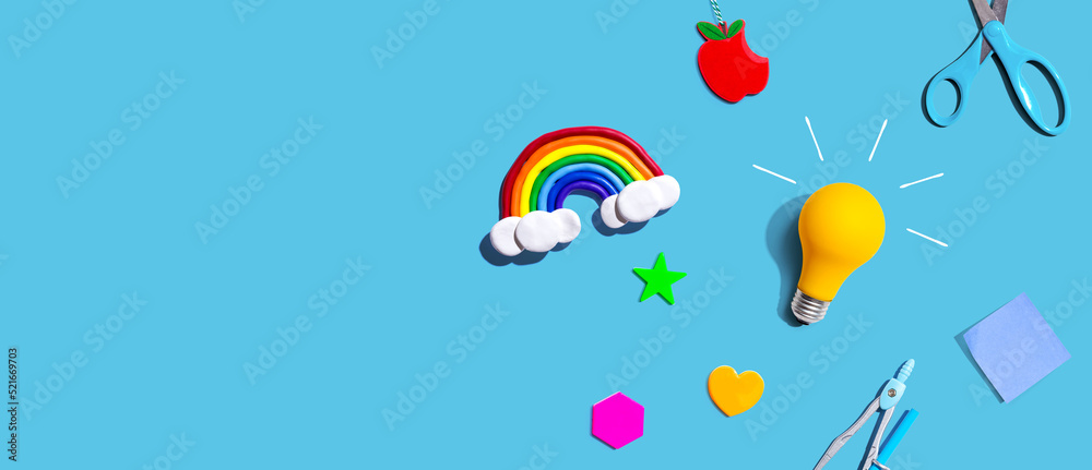 Idea light bulb with a rainbow and school supplies overhead view - flat lay