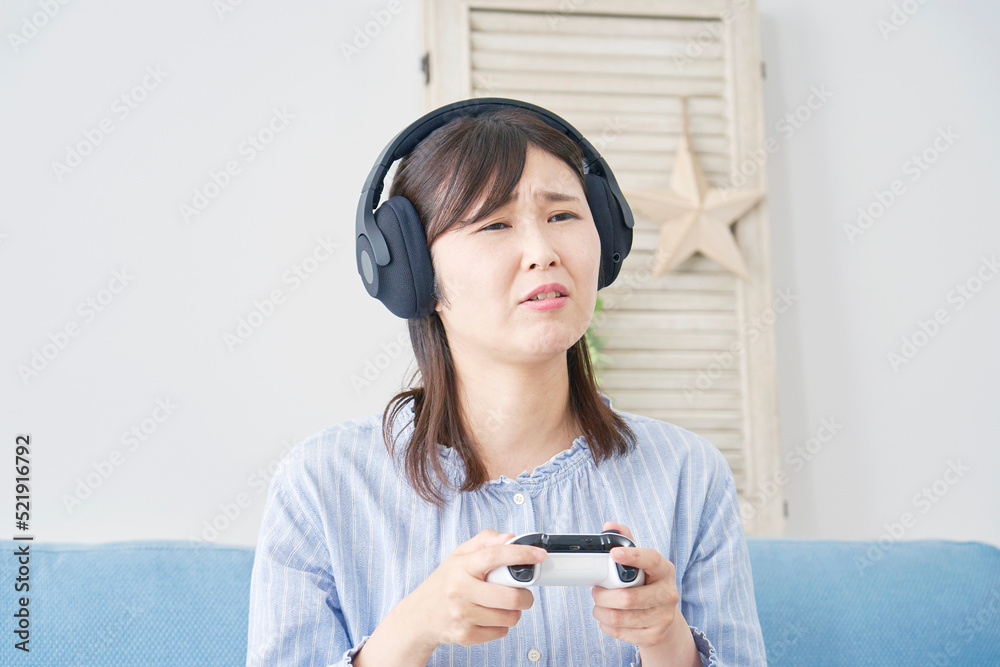 自宅で一人でテレビゲームをして落ち込む女性