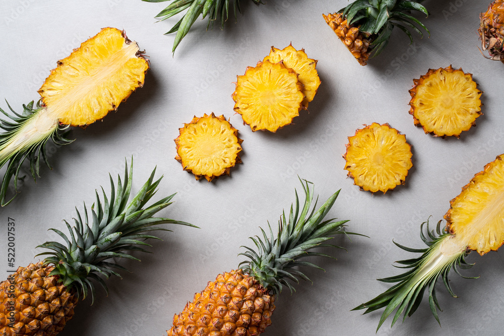 Fresh cut pineapple with tropical leaves on dark blue background.